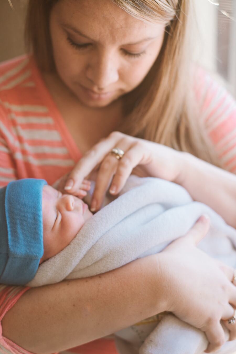 A mother cradling her sleeping newborn